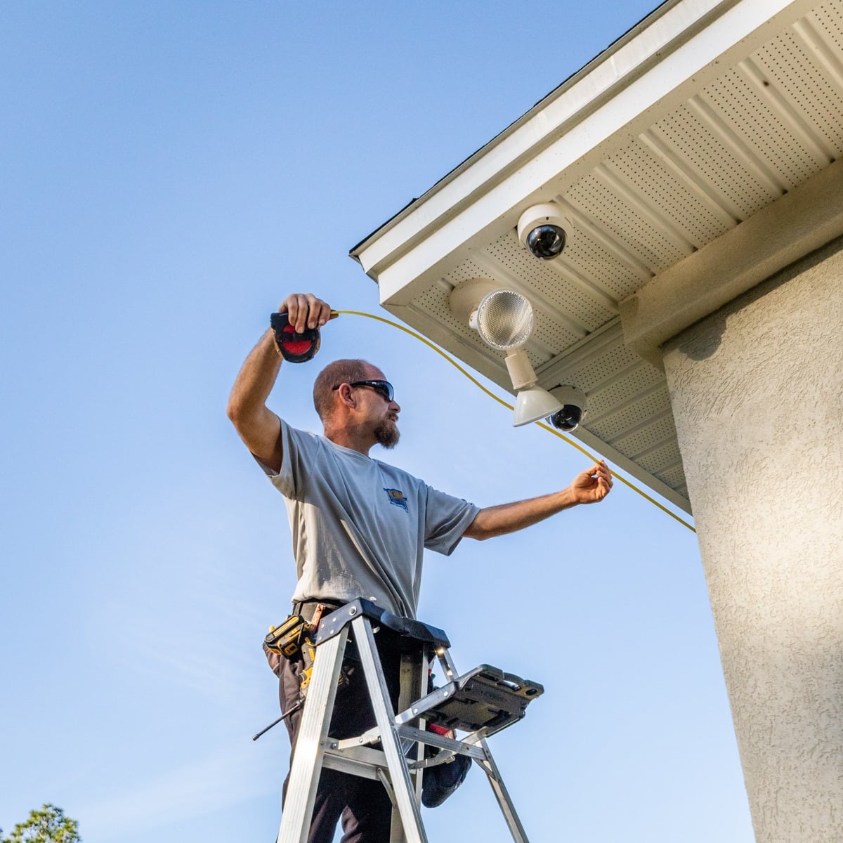 Man on a ladder measuring the lenght of the gutter